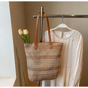 Détail du grand sac cabas en paille tissée à rayures brunes et longues anses en similicuir