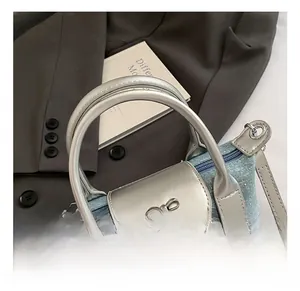 Close-up of denim blue mini bag with silver bow detail and star pattern texture