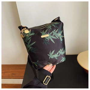 Close-up of black waterproof nylon bag with green leaf print and golden kangaroo pendant