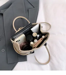 Vue du compartiment spacieux du sac seau crème avec accessoires et rangement intérieur