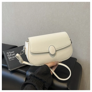 Detail of minimalist cream saddle bag with lychee texture flap and silver metal buckle