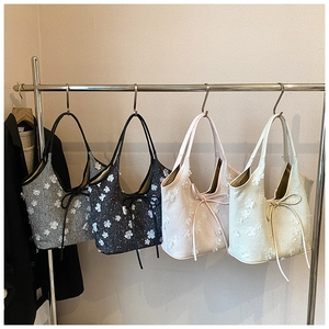 Selection of four chic bucket bags with 3D floral appliqués and bow details in soft colors