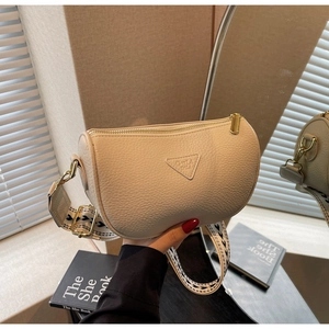 Detail of beige pebble leather shoulder bag with woven strap and triangle logo