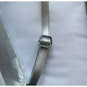 Detail of adjustable silver metallic leather strap with polished metal buckle and stitching
