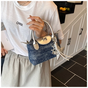 Detail of blue denim mini bag with silver bow, starfish pendant and metallic trim