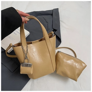 Detail of beige PU leather bucket bag set with decorative silver chain and mini pouch