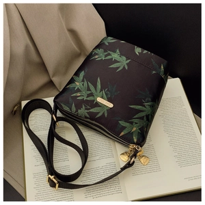 Close-up of waterproof nylon crossbody bag with green leaf print and metal logo detail