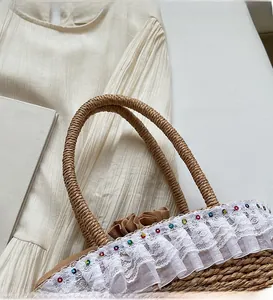 Detail of woven straw handbag featuring double-layer lace trim and colorful rhinestone accents