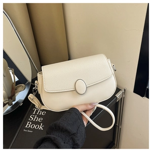 Detail showing creamy beige shoulder bag with mixed leather textures and metal clasp