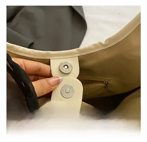 Detail of magnetic buckle closure and stitching on cream bucket bag interior