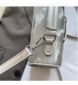 Macro shot of bright silver metal hooks and sparkling silver textured leather detail