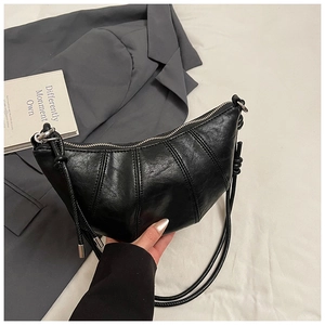 Detail of black crescent shoulder bag with pleated faux leather and decorative side knots