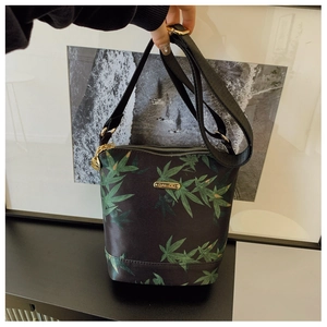 Detail of waterproof nylon bucket bag with green leaf pattern and adjustable strap