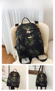 Detail of black DAILOU backpack with green leaf patterns and gold metal zippers