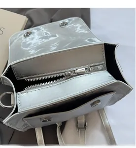 Detail view of the silver metallic bag showing the smooth zipper and dual magnetic closure