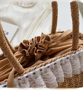 Close-up of handmade straw bag with lace trim and secure drawstring closure detail