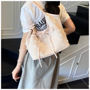 Detail of sweet floral tote bag with 3D white flowers and a decorative ribbon strap