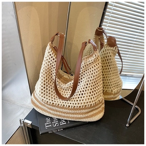 Detail of the woven hollow crochet pattern and brown leather strap on the beach bag