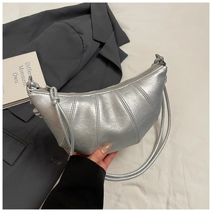 Detail of silver crescent bag with metallic finish and fine vertical stitching lines