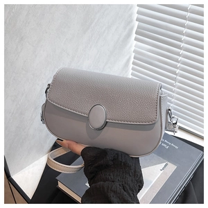 Detail of grey PU leather shoulder bag with lychee texture flap and oval buckle