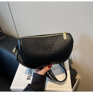 Detail of black lychee grain leather pillow bag with stylish geometric wide strap