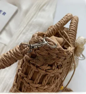 Detail of straw woven bag featuring silver metal hook and drawstring inner liner closure