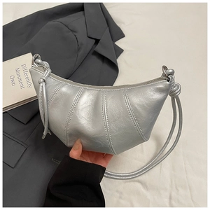 Detail of silver croissant bag featuring vertical pleats and metallic synthetic leather