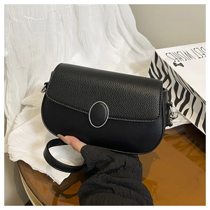 Close-up of black half-moon saddle bag with pebble grain texture and silver oval buckle