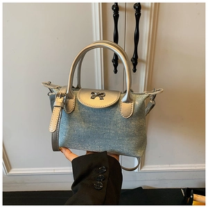 Detail of denim handbag with silver bow buckle and small metal studs decoration