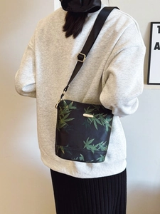 Waterproof nylon crossbody bucket bag with green leaf pattern and adjustable strap