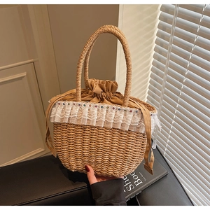 Detail of handmade straw handbag with white lace trim and drawstring closure for vacation
