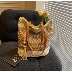 Détails du sac fourre-tout en paille tissé à la main avec anses brunes et gland décoratif