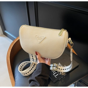 Detail of cream pillow bag showing lychee grain leather and herringbone strap texture