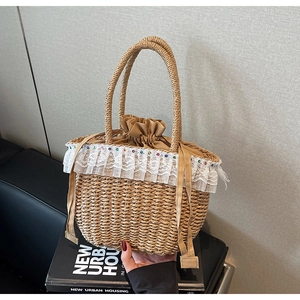 Detail of hand-woven straw bag featuring delicate white lace trim and colorful bead accents