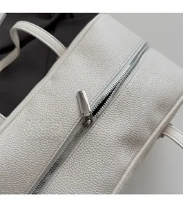 Close-up of silver zipper detail and white lychee grain leather on the bowling bag