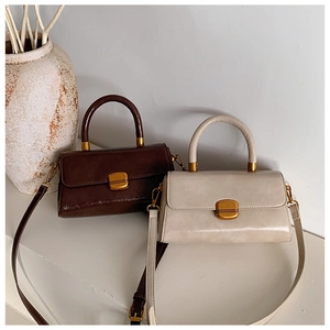Detailansicht der Retro-Handtaschen in Dunkelbraun und Beige mit goldenen Metallschnallen