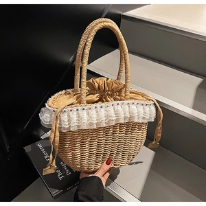 Close-up of woven straw handbag featuring delicate lace trim and colorful stud details