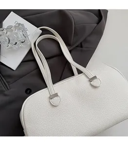 Detail of white lychee leather tote bag with square metal buckles and long shoulder straps