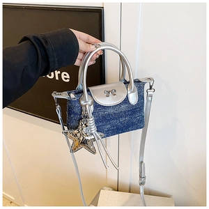 Detail of mini denim handbag with silver bow, glitter stars and metallic handle