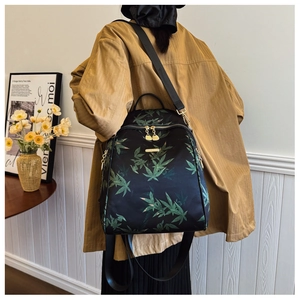 Detail of high-density nylon backpack with green bamboo leaf print and gold hardware