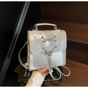 Détails du sac à dos argenté avec pendentif papillon et décorations de glands perlés