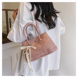 Sac seau rose en cuir PU avec nœud en dentelle blanche et perle porté par un mannequin