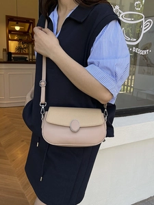 Minimalist bicolor saddle bag with beige leather texture and silver buckle detail