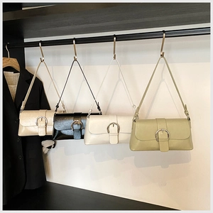 Row of faux leather shoulder bags in beige black and green with metal pin buckle closure