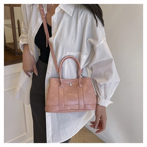 Détail du sac cabas en cuir rose avec boucle argentée et bandoulière réglable pratique