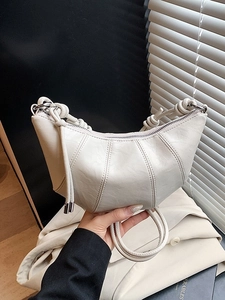 Chic beige croissant bag with knotted handle and vertical stitching detail