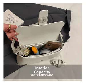 Detail showing internal capacity of white faux leather shoulder bag with makeup items