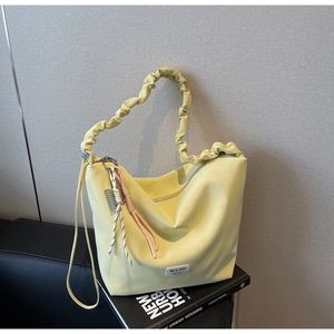 Detail of light yellow large tote bag with pleated strap and MULAIDI logo tag