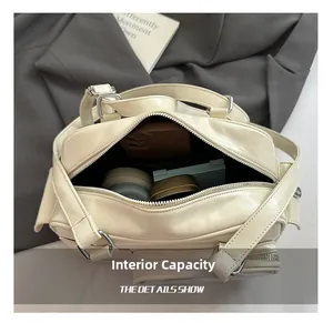 Top view of the cream shoulder bag showing internal capacity with phone and cosmetics