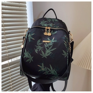 Detailed shot of waterproof backpack with green leaf patterns and premium golden hardware